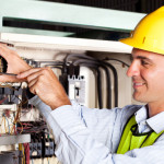 male electrician repairing industrial machine control component